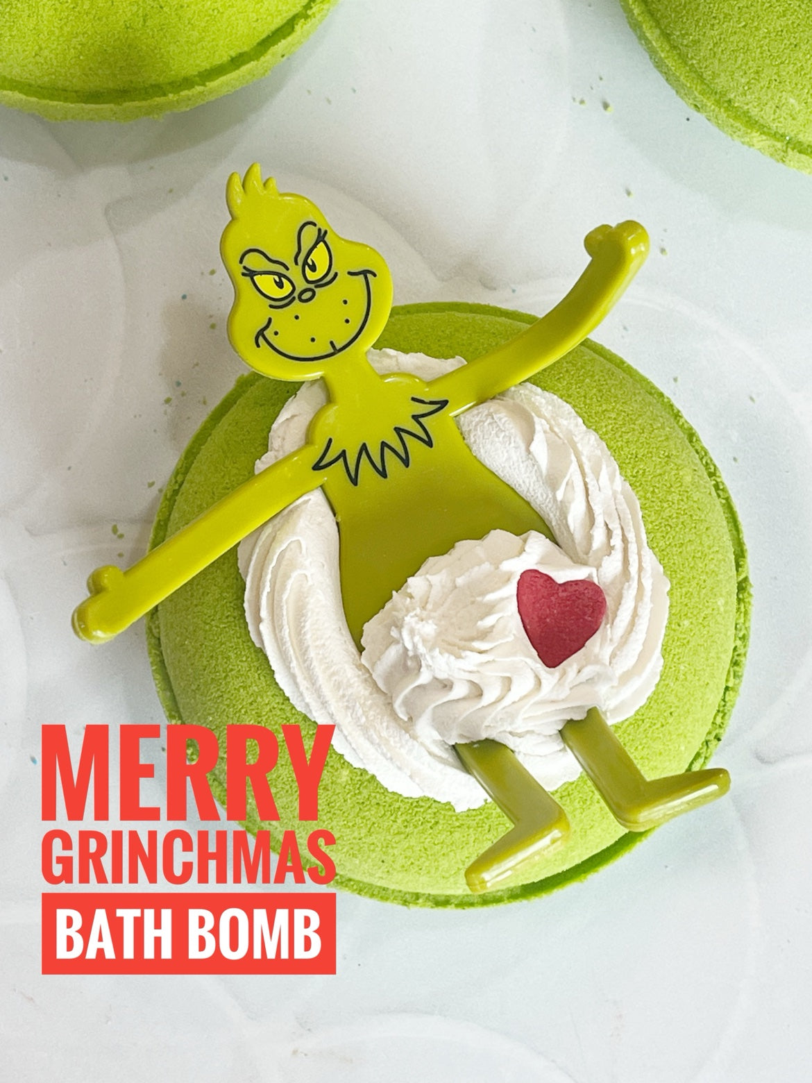 Merry Grinchmas Bath Bomb by Glitzy Waters — bright green bath bomb with white frosting swirl and red heart, Mahogany Teakwood scent